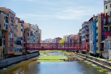 the river runs through a city with a red bridge on it