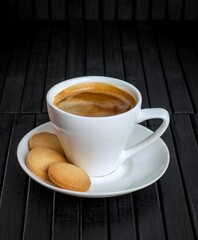 coffee in a cup with cookies on a saucer next to it