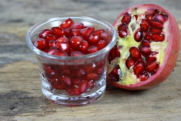 Ripe pomegranate cut in half, revealing the juicy red arils inside
