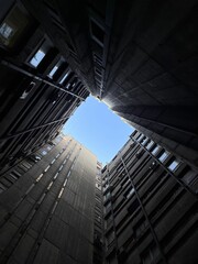 a black square in between some tall building with windows in it