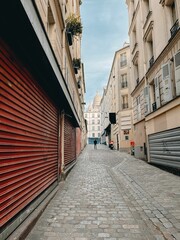Empty street with closed shutters on the buildings lining the roadway