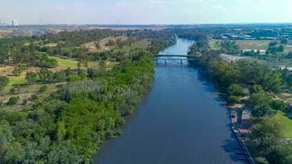 Fototapeta premium Aerial view of a bridge on a winding river in a green landscape