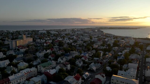 Captured in 4K, a late-night sunset bathes Reykjavik in soft light at 11pm, showcasing summer in Iceland as the sun dips below the cityscape in August.