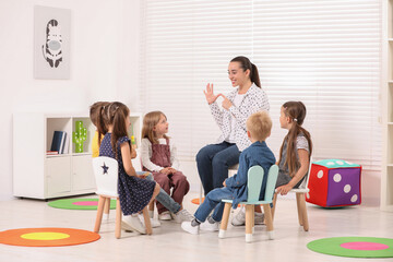 Nursery teacher and group of cute little children learning numbers in kindergarten. Playtime...
