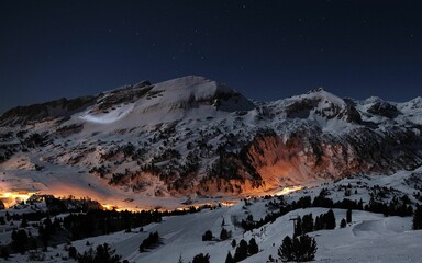 Scenic view of a mountain range covered with snow at night