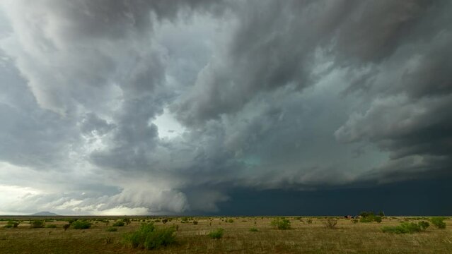 Shelf cloud looms over the New Mexico landscape with mountains in the distance.
