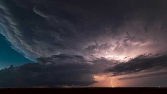 A massive supercell churns through the New Mexico landscape after dark. Stars shine as the storm spins into the night.