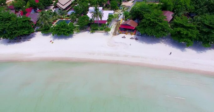 Panning from right to the the left side of the frame of an overhead drone shot of Thong Nai Pan Yai Island beach front, at Koh Pangan in the the South of Thailand.