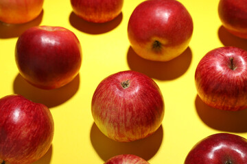 Ripe red apples on yellow background, closeup
