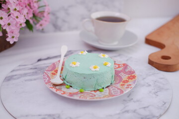 Green tea mousse cake with cup of coffee on the table.
