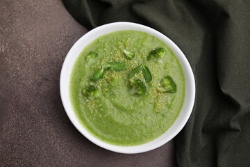 Delicious broccoli cream soup on grey table, top view
