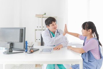Obraz premium Asian doctor talk with children patient about disease symptom, doctor use hand touch on hand of patient, they hi five together, children health check up, happiness hospital