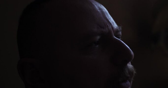 Unhappy, middle aged man drinking liquor. Alcoholic man alone in his apartment drinking alcohol.