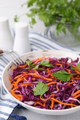 Tasty salad with red cabbage in bowl on light grey table, closeup