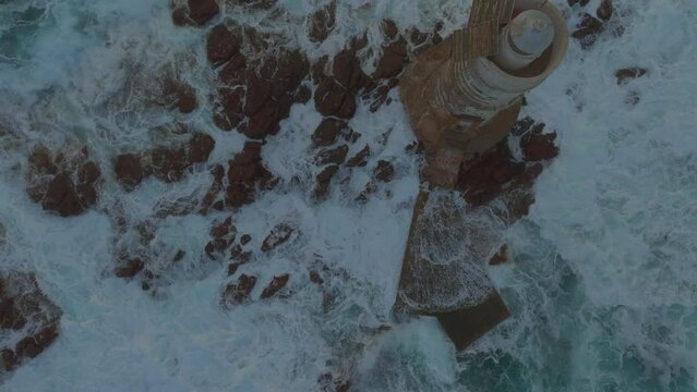 Mangiabarche Lighthouse, Sardinia: Fantastic aerial view from above discovering the beautiful lighthouse and the fury of the waves during the sunset.