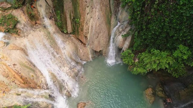Descending aerial view of limestone Kinahugan waterfall, Philippines