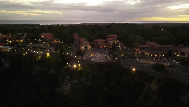 Aerial view of Altos de Chavon with its green areas and cloudy sky at sunset.