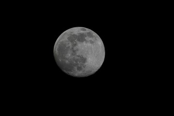Luminous full moon illuminated against a dark night sky, creating a serene atmosphere