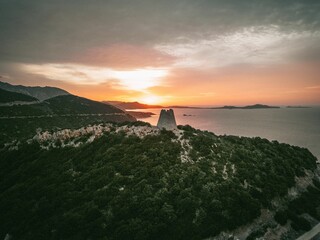 Tranquil landscape captured at sunrise with a watchtower on the coast of Italy