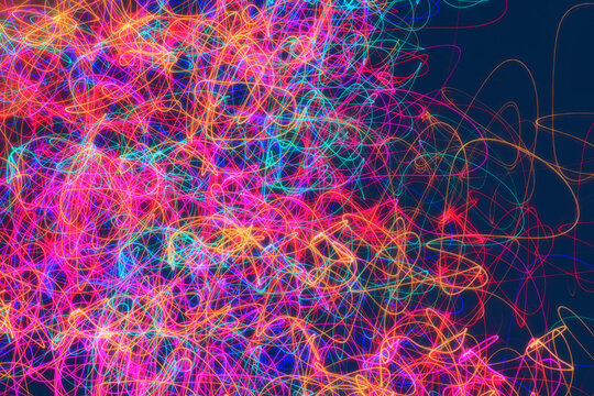 Abstract light painting of multiple glowing neon colors, with a chaotic squiggle pattern that trails off toward the right edge of the image.
