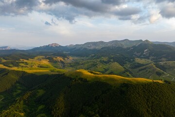 Fototapeta premium Aerial view of green hills at sunset