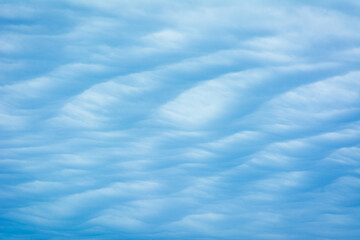 Abstract blue tinted cloud texture with a wavy, sand dune pattern.