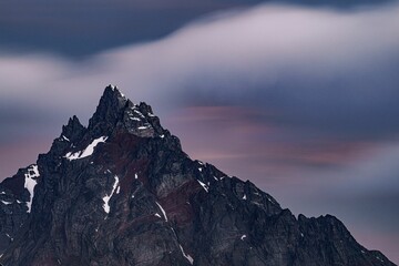 Scenic view of a mountain peak against a cloudy sky at sunset
