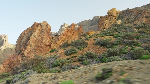 Driving along rocky mountains at Teide National Park in Tenerife during sunset, closeup low angle parallax