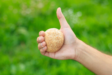 Man's hand holds mini bread, snack and fast food concept. Selective focus on hands with blurred background