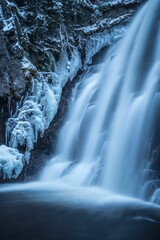 water running over some ice covered rocks on the side of a river