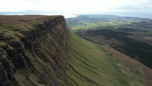 Drone footage over Benbulbin mountain rock formation and green valley