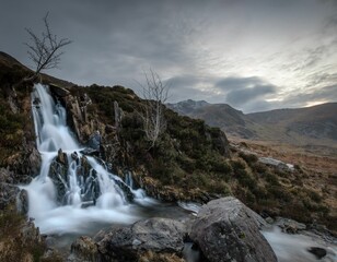 Majestic waterfall cascades down a rugged hillside in the Y Garn Mountains of Wales