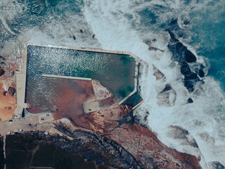 Aerial view of a stunning landscape featuring large rocks and sea, Bermagui Rock Pool, NSW