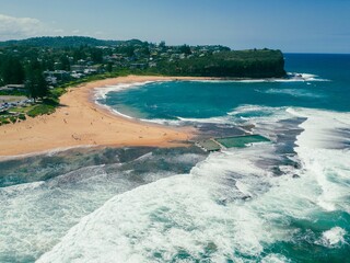 Picturesque coastline view of a beach town featuring rolling waves and shoreline,Mona Vale Rock Pool