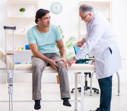 Young leg injured male patient visiting old doctor