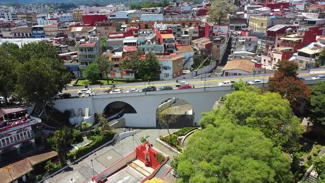 Aerial drone tilt up shot over a historical bridge of Xalapa, Xalapa city, Veracruz, Mexico at daytime, colorful city in summer travel over america historic place touristic point.
