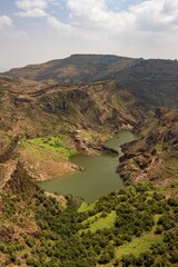 Obraz premium Aerial view of a water dam surrounded by greenery in Ibb city, Yemen