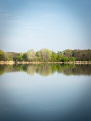 Obraz premium Tranquil lake surrounded by greenery, offering a peaceful and inviting atmosphere