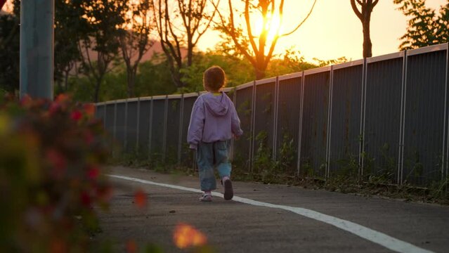 Sad Little Girl Walking Alone at Sunset in Slow Motion with Sun Setting Behind Mount