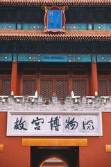 Vertical shot of Chinese signs over the door of an Asian architecture