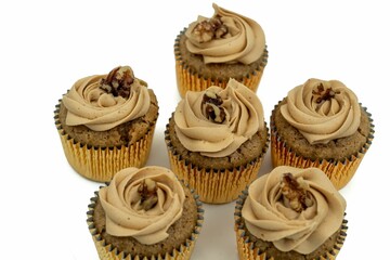 Top view of vegan walnut cupcakes on a white backdrop.