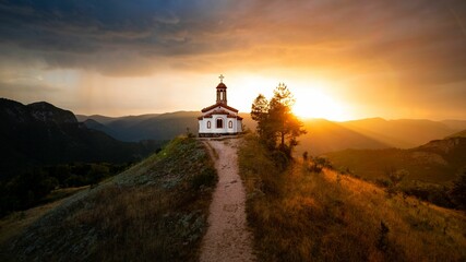Small chapel on top of a hill during sunset - obrazy, fototapety, plakaty