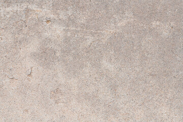 Detail of a section of weathered concrete sidewalk with a rough texture, gray colors, and thin...