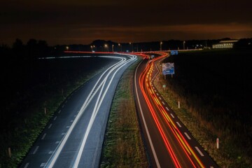 Aerial long-exposure view of car light trails on a highway road at night