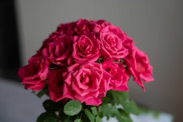 a vase filled with pink roses sitting on top of a white table