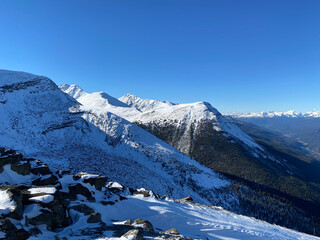 there is snow on the ground near the mountains and the sky