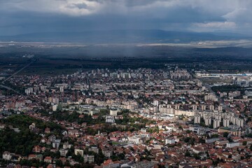 Aerial shot of the cityscape of Brasov, Romania under a cloudy sky.