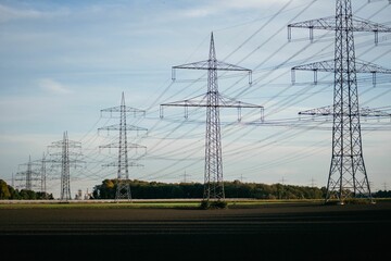 Verdant countryside with multiple electricity towers, set against a clear blue sky