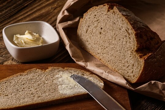 Image of freshly-baked bread spread with a generous layer of butter