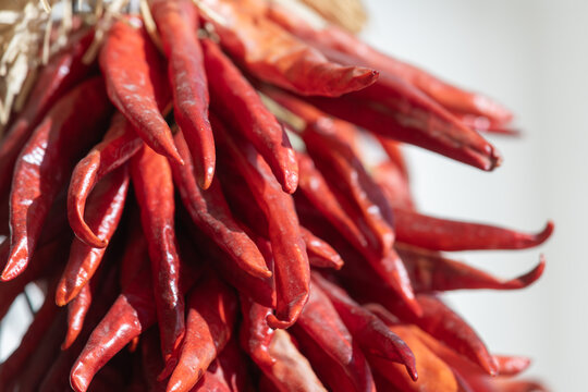 Close up detail of a red chile ristra, dried red chile peppers strung together to create a decorative display.